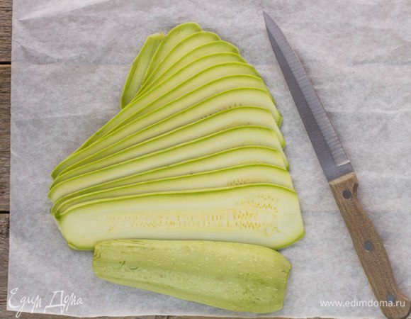 Кабачки помыть и нарезать тонкими ломтиками вдоль.