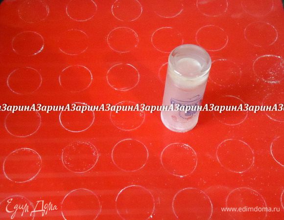 Поместить тесто в кондитерский мешок с круглой насадкой. Подготовить силиконовый коврик. Если у вас простой, не специальный коврик, то при помощи рюмки диаметром 4 см сделайте на коврике круги, окуная её в сахарную пудру.