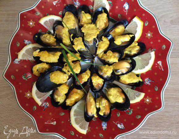 Добавляем в раковинки с мидиями шафрановый соус. Режем также лимон и зеленый лук по своему вкусу.