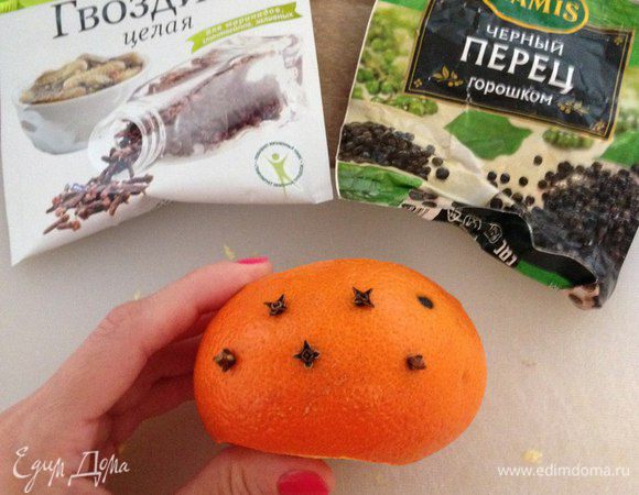 У мандарина срезаем верх и низ. Выжимаем немного сока в стакан и пробиваем мандарин гвоздикой и перцем.