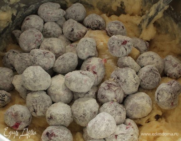 Муку смешать с разрыхлителем, просеять и постепенно добавить, перемешивая ложкой. У вишни удалить косточки, обвалять в муке и добавить в тесто.