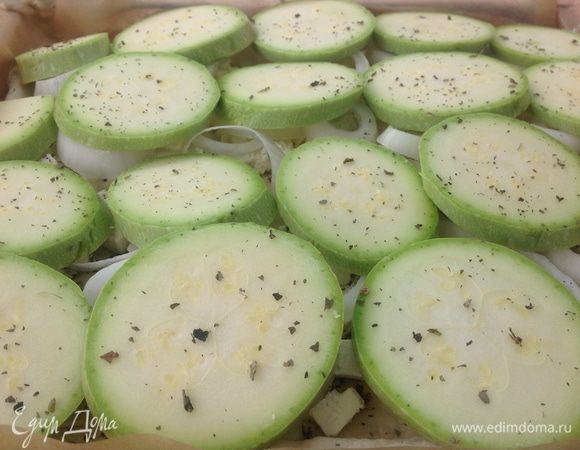 Поверх лука - кабачки, порезанные не тонкими кольцами, присыпаем их немного еще базиликом и смазываем оливковым масло каждый кружок кабачка.