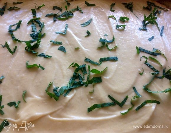 На пергаментную бумагу, посыпанную молотыми сухарями или крупной кукурузной мукой, выливаем тесто (форма у меня размером 25*30 см),
разравниваем тесто ложкой и посыпаем порезанной свежей мятой.