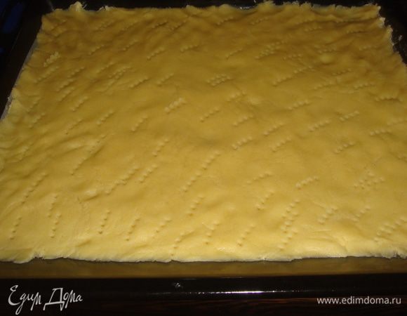 Нагреть духовку до 180 градусов. Противень смазать маслом. Тесто раскатать, положить в противень, наколоть вилкой.