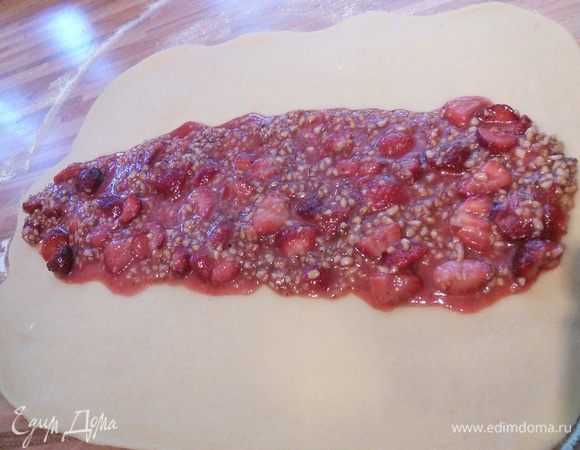 Подошедшее тесто разделите на две части,  раскатайте первую часть в прямоугольник приблизительно 30 на 40 сантиметров,  выложите на тесто половину начинки. Тесто скрутите в рулет и закрепите концы. Тоже самое проделайте со второй частью теста. 