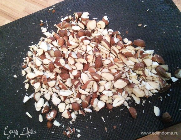 К этому времени остывший миндаль выложить на доску и порубить тяжелым ножом  не слишком  мелко. 