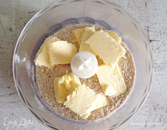 Просеянную муку, холодное сливочное масло и соль помещаем в чашу блендера и измельчаем в крошку. Добавляем 3-5 ложек ледяной воды и еще раз перемешиваем. 