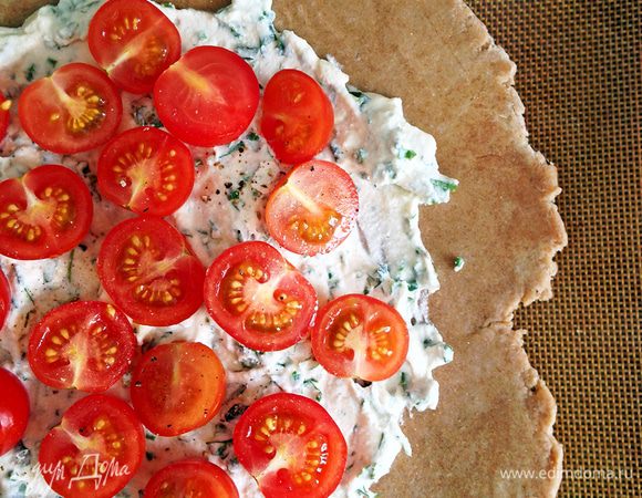 Выкладываем начинку, равномерно ее разравниваем, оставляя нетронутыми края (3-5 см). Поверх раскладываем половинки томатов. 