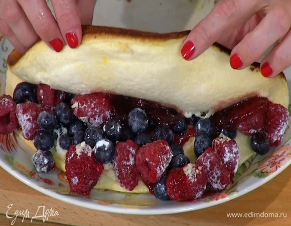 Готовый омлет полить малиновым вареньем, на одну половину выложить ягоды и накрыть второй половиной. Посыпать все оставшейся сахарной пудрой.