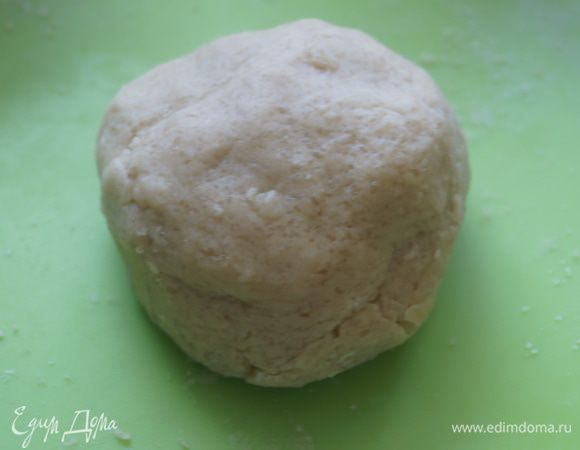 Сначала приготовим кракелюр. Для этого на чистую сухую поверхность насыпать горку муки, сахар и сливочное масло нарезанное на кусочки. Растереть все в крошку.
Замесим тесто, затем скатаем его в шар, завернем в пищевую пленку. После чего уберем в морозильную камеру на 15 минут.