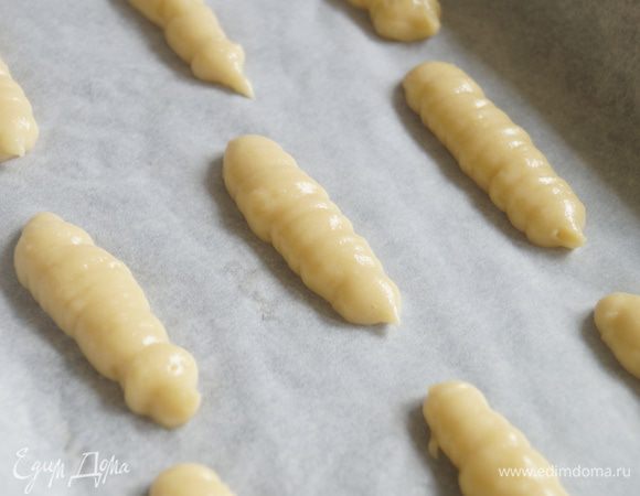 Из полученного теста, при помощи кондитерского мешка, отсадим на противень застеленный пергаментом небольшие палочки, оставляем между ними свободное место около 3 см.