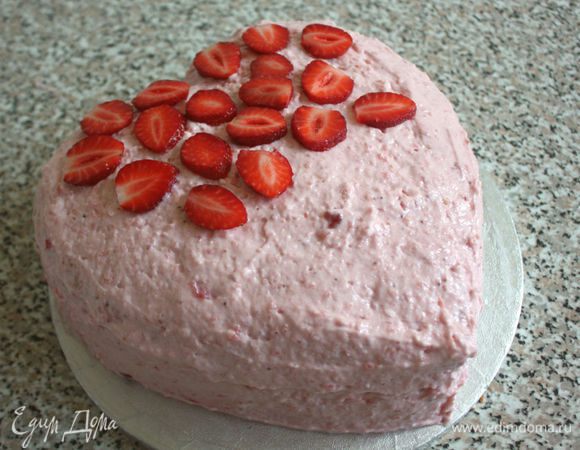 Обмазать верх и бока кремом, придавая ему куполообразную форму. Поверх крема достаточно плотно выложить нарезанную клубнику.