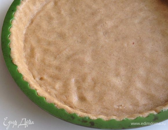 Тесто раскатать между двумя листами бумаги для выпечки аккуратно выложить в форму. Лишнее тесто срезать и подровнять бортики.