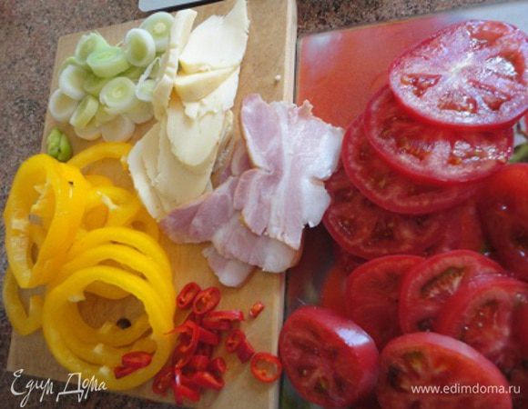 Порей нарезать кружочками. Также очищенные от семян перцы и помидоры. Оливки разрезать вдоль на половинки. Сыр и корейку нарезать ломтиками.