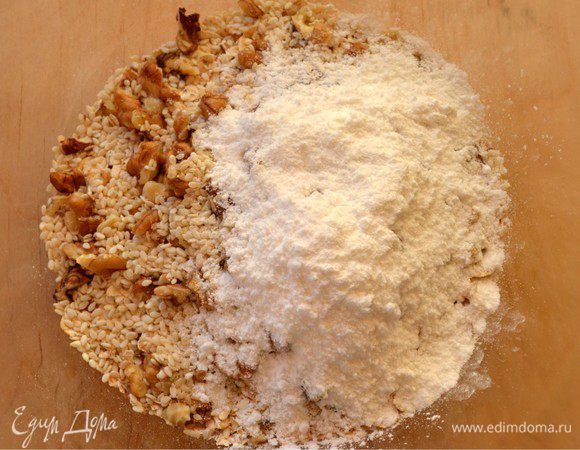 В миске смешать овсяные хлопья (лучше крупные), орехи, кунжут, ванилин и сахарную пудру.