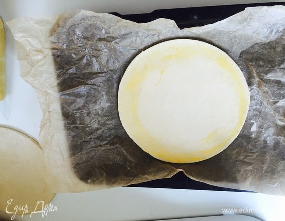 Меньший круг переносим на пергаменте на противень. Смазываем края яйцом.