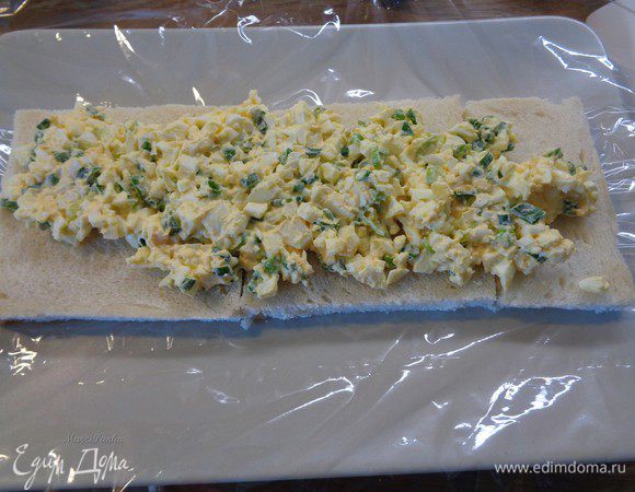 Все начинки смешать в отдельных мисочках. Для 1-ой начинки яйца отварить вкрутую. Для 2-ой лосось мелко порезать. Для 3-ей использовать сливочное масло комнатной температуры.

Блюдо для закусочного торта выстелить пищевой пленкой. Выложить на него кусочки хлеба. При необходимости подрезать. Покрыть первый слой хлеба 1-ой начинкой.