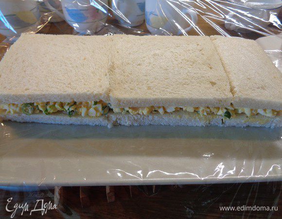 Сверху уложить второй слой хлеба. Немного придавать рукой.