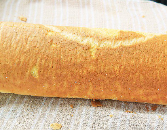 Готовый бисквит опрокинуть на посыпанное сахаром полотенце и, удалив бумагу, свернуть в рулет.