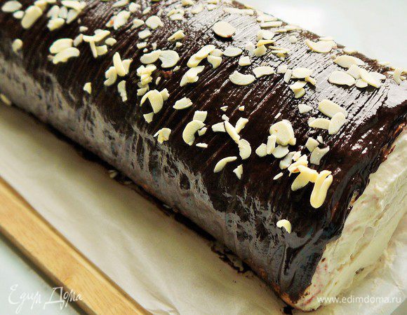 Достаем рулет из холодильника. Кулинарной кистью аккуратно обмазываем рулет ганашем и посыпаем готовый рулет миндальными лепестками. Ставим в холодильник на 1 час.