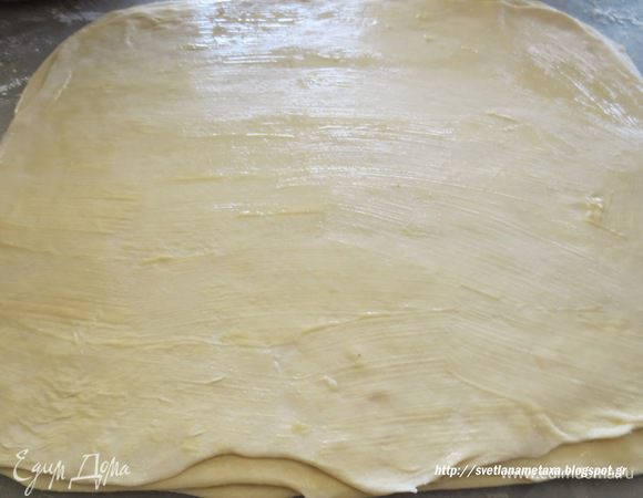 Готовое тесто еще раз обмять и разделить на 4 одинаковые части. Из каждой части раскатать тонкий листы. Каждый лист смазать растопленным сливочным маслом и сложить стопкой один на другой.