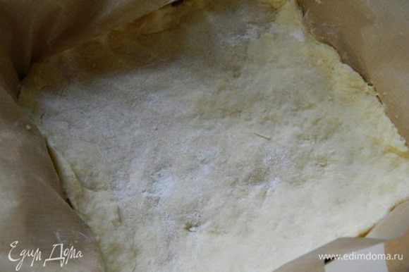 Форму застелить пекарской бумагой и уложить тесто, сделать высокие бортики. Убрать в холодильник на 30 минут.