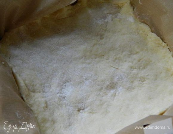 Форму застелить пекарской бумагой и уложить тесто, сделать высокие бортики. Убрать в холодильник на 30 минут.
