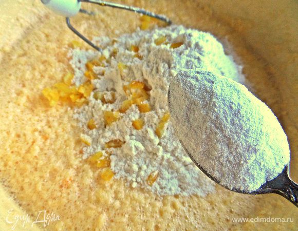 Добавить цедру в тесто и постепенно всыпать просеянную муку.