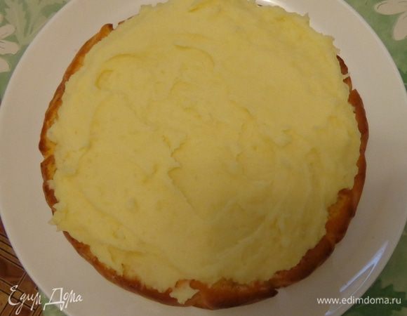 Сварить картошку, сделать пюре, добавив по вкусу соль, перец и сухие травки. Для вкуса и вязкости положить сливочный сыр и сливочное масло. Покрыть картофельным слоем первый корж.