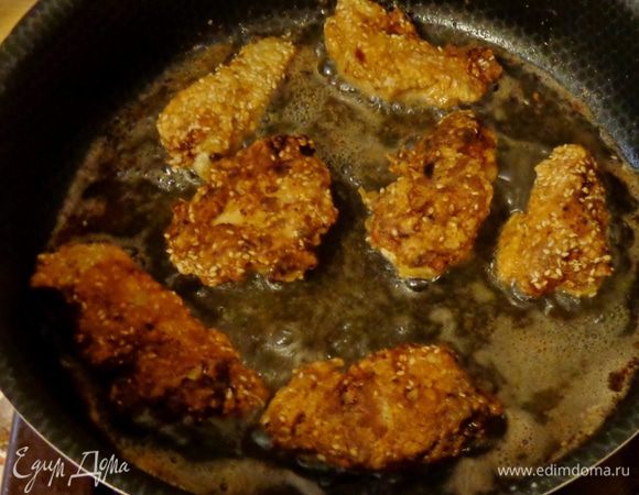Промариновавшиеся кусочки курицы обвалять в муке, затем в яйце и в смеси муки с кунжутом. Обжарить на сковороде.