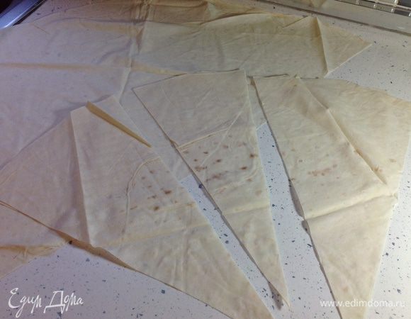 Расстелить тесто на столе. Разрезать на 12 частей треугольной формы. Это удобно делать, разрезав тесто пополам, потом, сложив половинки друг на друга, еще раз пополам и т.д. до нужного размера.