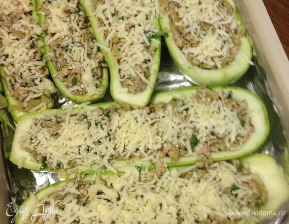Смешиваем кабачки, лук, фарш. Пробуем, приправляем по вкусу. Я еще добавила петрушку. Укладываем начинку в лодочки. Посыпаем сыром. 