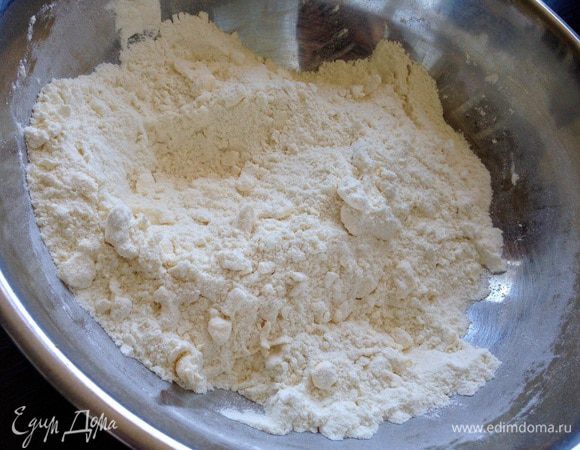Просеять муку и смешать с сахаром, ванильным сахаром, разрыхлителем и солью. Добавить кусочки охлажденного масла и растереть с мукой в крошку.