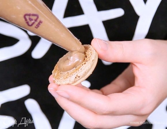 На одну половинку макаронс отсадите порцию крема, затем накройте второй половинкой. 