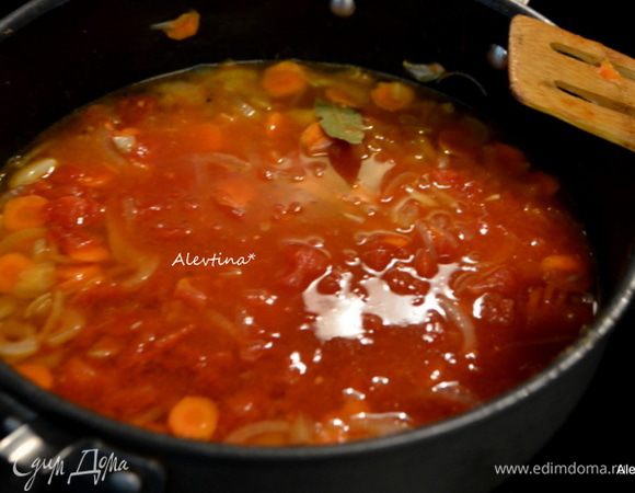 Добавим бульон, томаты баночные порезанные кубиками в собственном соку, вино, лавровый лист. Перемешаем.