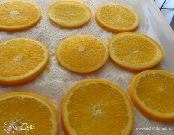 Вымоченные апельсины выложить на полотенце, обсушить и опять поместить на сковороду. Залить сиропом и поставить на очень маленький огонь.