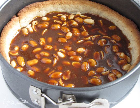 По дну тарта распределить соленый арахис и вылить на него карамельный соус. Убрать в холодильник на пол часа для застывания карамели.