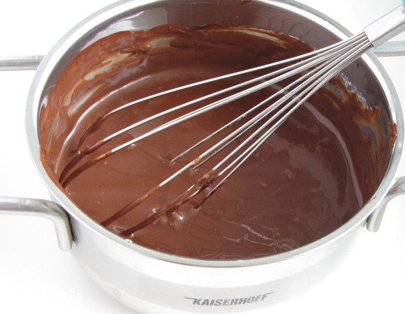 Снять с огня и добавить поломанный на кусочки шоколад. Оставить на пару минут, затем размешать до однородности.