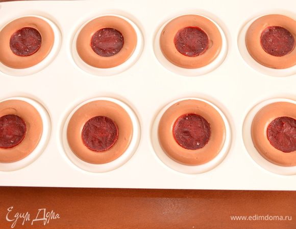 Мусс выкладываем по 8 формочкам. Проще всего это сделать из кондитерского мешка. В центр утапливаем замороженное кули из малины (не утапливайте слишком глубоко, чтобы после сборки не было щели между бисквитом и кули, как получилось у меня и видно на разрезе). Отправляем в морозилку.