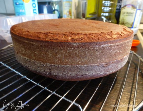 Готовый корж вынимаем из формы и остужаем на решетке. Срезаем вздувшуюся верхушку и оставляем ее для приготовления трюфелей. Сам бисквит заворачиваем в пищевую пленку и убираем в холодильник на 1-3 суток. За это время корж станет более влажным с ярким шоколадным вкусом.
