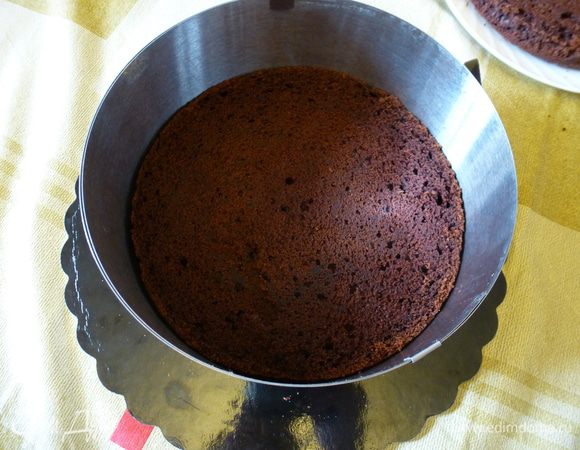 Для сборки торта нам потребуется кулинарное кольцо или кольцо от разъемной формы, по размеру бисквита. На дно кольца выкладываем первый корж.