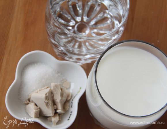 Соединить воду и молоко, слегка подогреть. Растворить в жидкости сахар и свежие дрожжи.