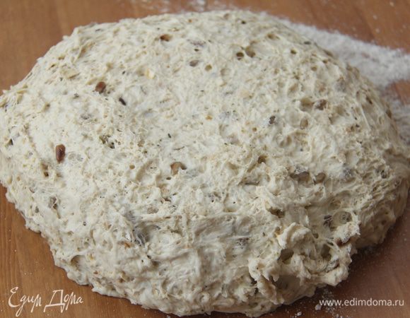 Через 2 часа выложить тесто на присыпанный мукой стол, обмять, сформировать батон, обвалять в ржаной или пшеничной цельнозерновой муке. Оставить на расстойку на 1 час, прикрыв полотенцем.