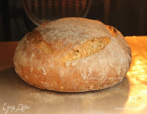 Духовку прогреть до максимума (у меня 250*С) вместе с противнем. 
На хлебе сделать насечки. Выложить батон на горячий противень, выпекать при 250*С 10 минут, затем убавить температуру до 180*С и выпекать ещё 25 минут. Остудить хлеб на решётке.
