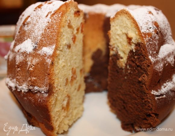 Форму для кекса смазать маслом. Поочередно выложить в неё светлое и тёмное тесто. Выпекать 50-60 минут. при температуре 175 ℃. Кекс украсить сахарной пудрой. 