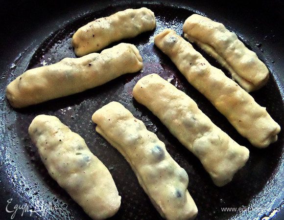 Раскатала на прямоугольники, положила по горсточке черники и закрутила "сигаретками". Смазала маслом и присыпала тоже сахаром. Отправила выпекать.