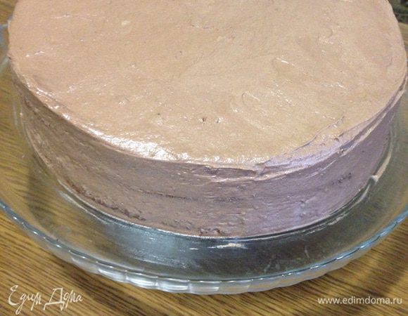 Сборка торта. Выкладываем на блюдо корж, пропитывать сиропом бисквит не надо, потому что бисквит не сухой. Смазываем корж кремом, так повторяем два раза. Выравниваем бока и верх торта кремом. Ставим в холодильник. В это время варим глазурь, в сотейнике смешивает мягкое сливочное масло с сахаром, добавляем какао, перемешиваем, добавляем молоко, ставим на медленный огонь, как только появляются маленькие пузырьки выключаем, даем остынуть. 