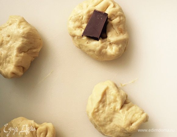 Кусочки из Белого теста слегка приплющиваем, в центр утапливаем дольку шоколада, формируем шарик, оставляем.