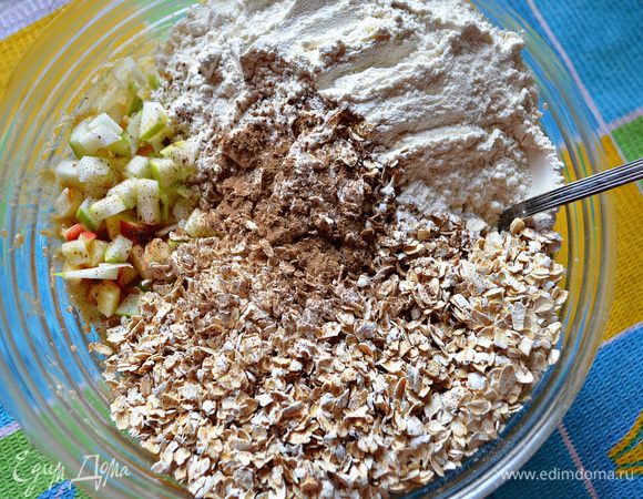 Затем добавьте муку с разрыхлителем и корицей, соль, овсяные хлопья и порезанные кубиками яблоки. Хорошо перемешайте. 