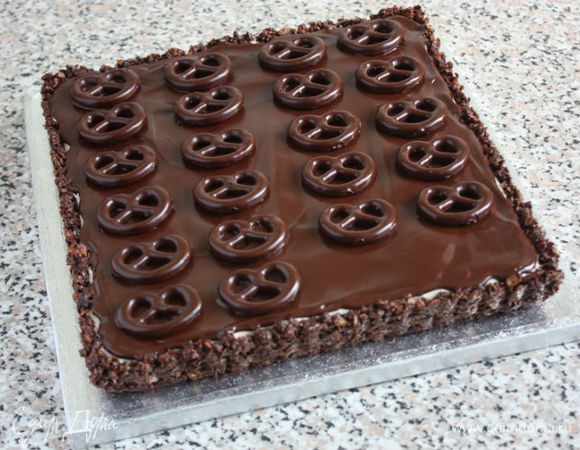 Оставшийся в миске шоколад вновь подогреть и распределить равномерно по крему. Ножом снять с  пергамента бретцели и выложить на шоколад. Поставить пирог в холодильник на 1 час.

